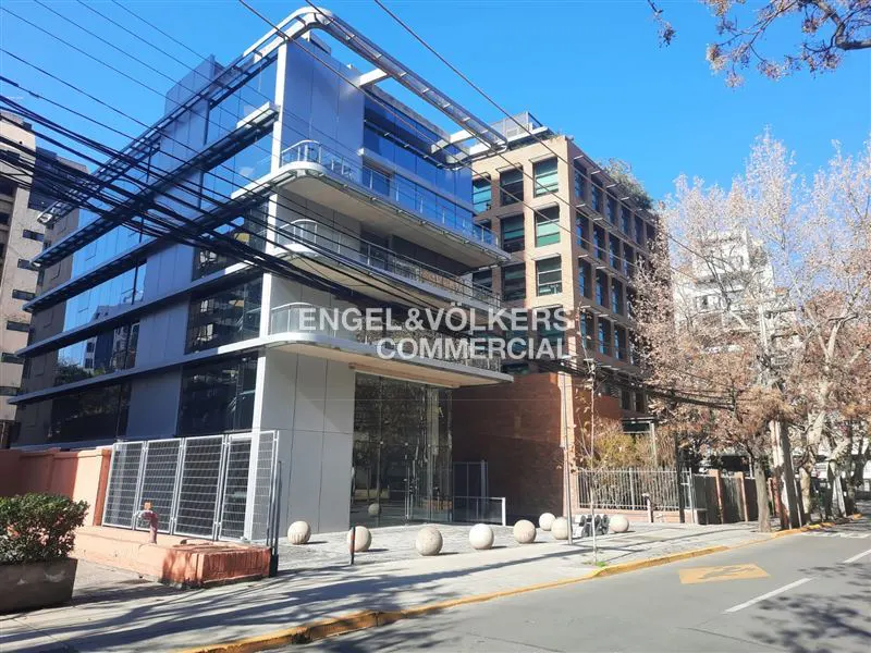 Engel & Völkers Commercial building with glass facade and modern design on a sunny day. Street view with trees.