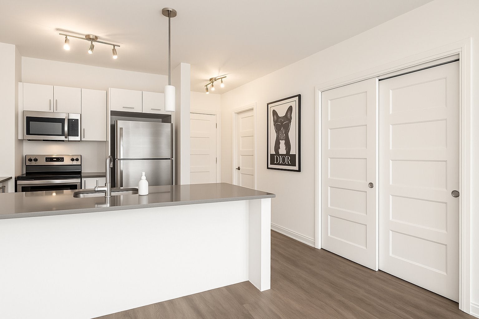Modern kitchen with white cabinets, stainless steel appliances, grey island, and a framed French bulldog Dior poster. [AI-generated text]