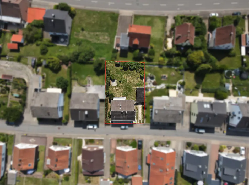 Aerial view of a house with a brown roof and a green lawn, surrounded by a red border, in a suburban neighborhood.
