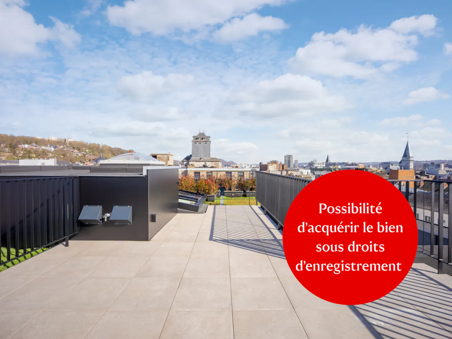 Rooftop view with gray tiles, black railings, and city skyline under a blue sky. A red circle highlights text in French.