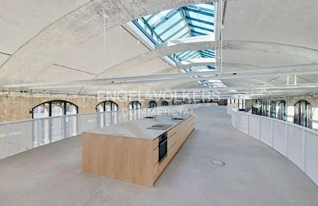 Interior view of a modern kitchen with a large island, skylight, and white railings.
