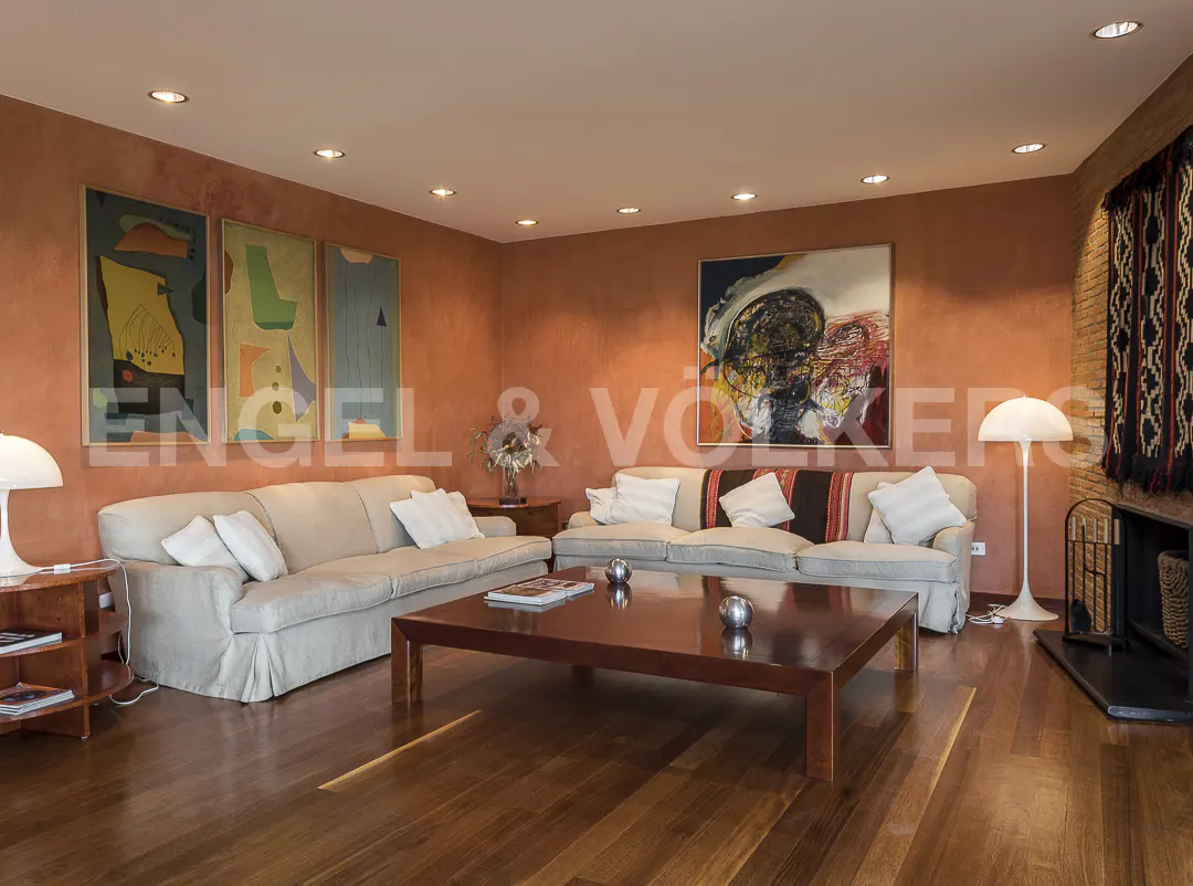 Living room with hardwood floors, two sofas, a large coffee table, and artwork on the orange walls.