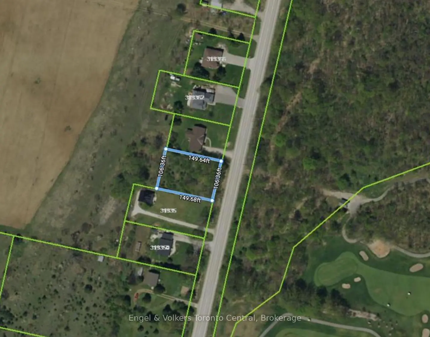 Aerial view of a vacant lot outlined in blue, adjacent to a road, with houses and a golf course nearby.