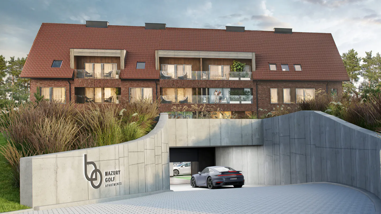 A grey sports car enters the underground garage of the Mazury Golf Apartments, a brick building with a red tiled roof.