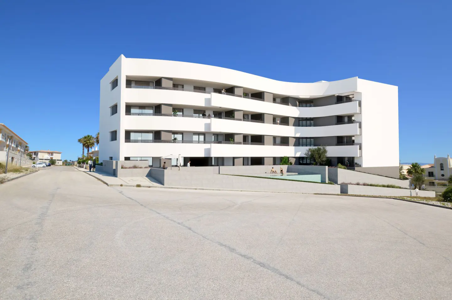 Modern white apartment building with curved balconies and a swimming pool, set against a clear blue sky.