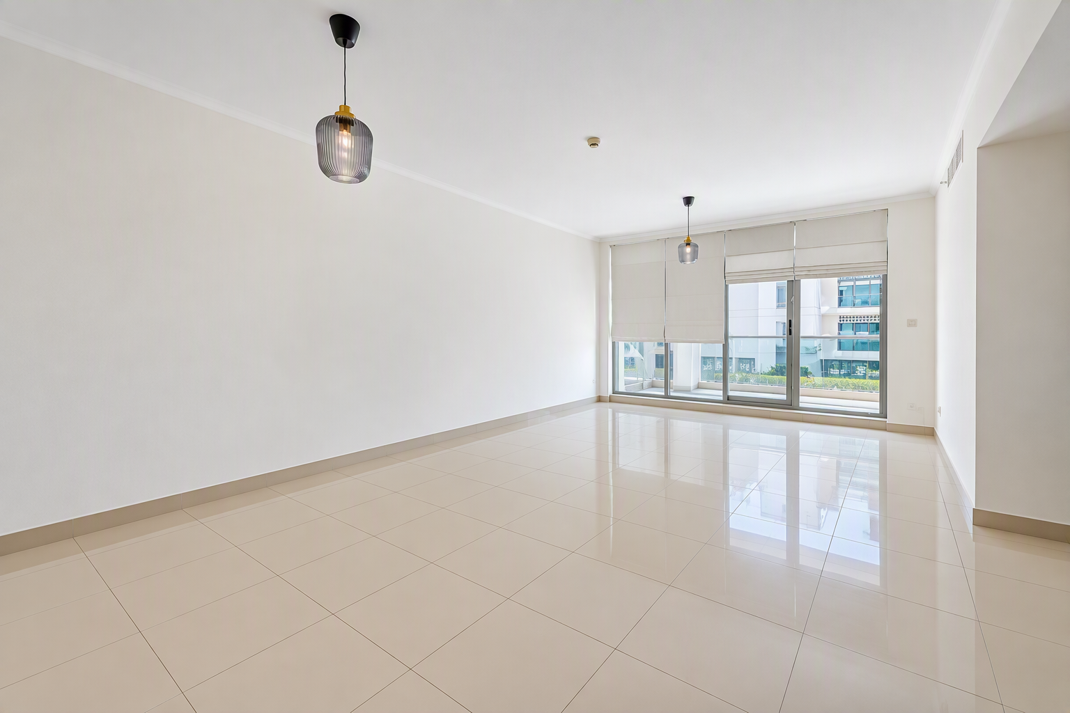 Empty, bright living room with white walls, glossy beige tile floors, two modern pendant lights, and a glass balcony door. [AI-generated text]