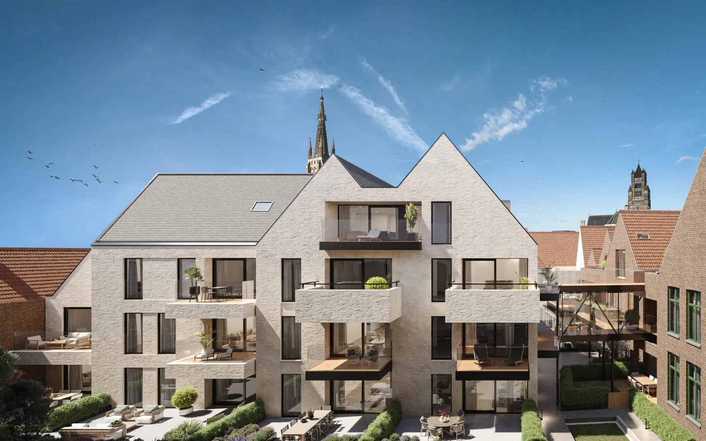 Exterior view of a modern, light-stone apartment building with balconies and a gray roof under a blue sky. A church steeple is visible in the background.