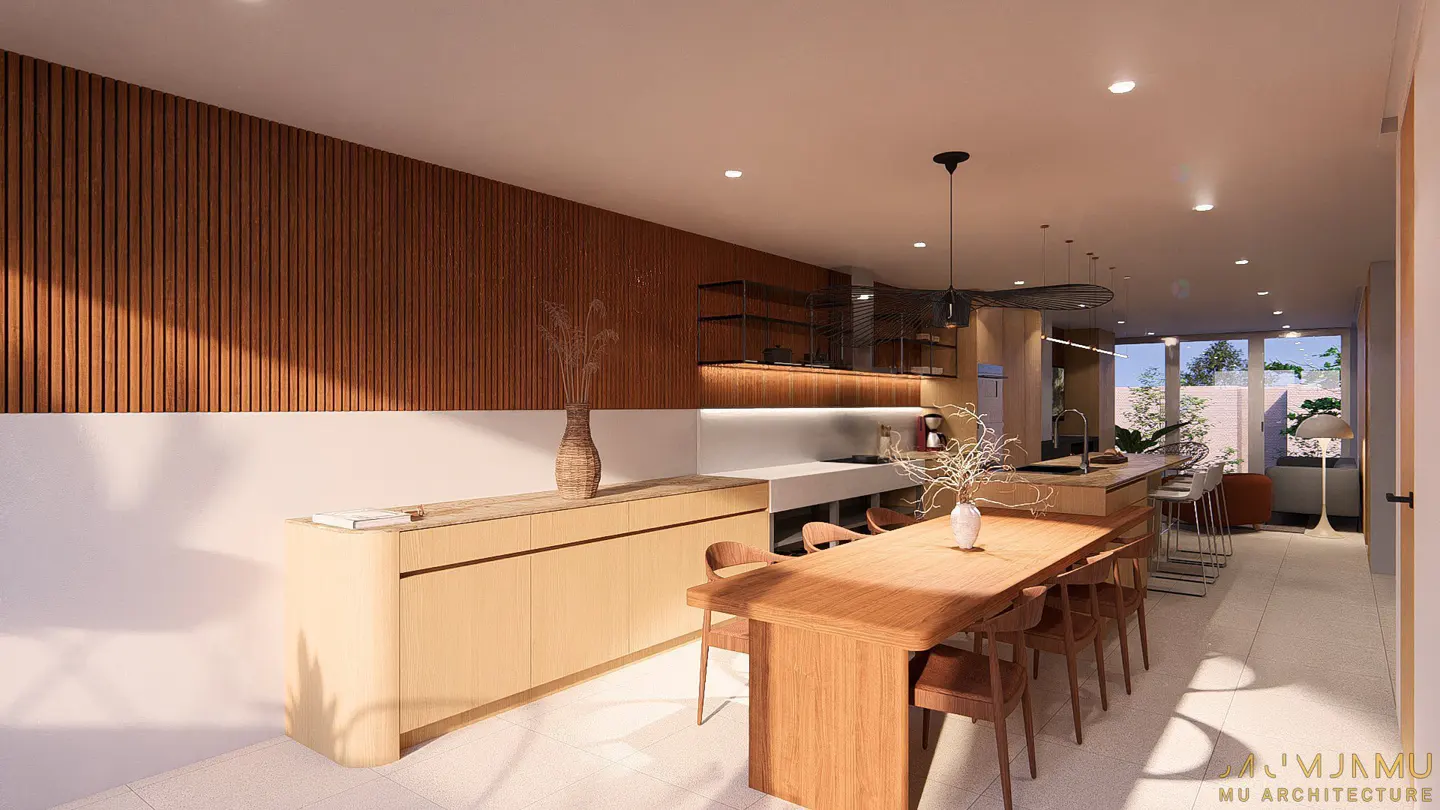 A modern kitchen with a long wooden table and chairs, light wood cabinets, and a wood-paneled wall.