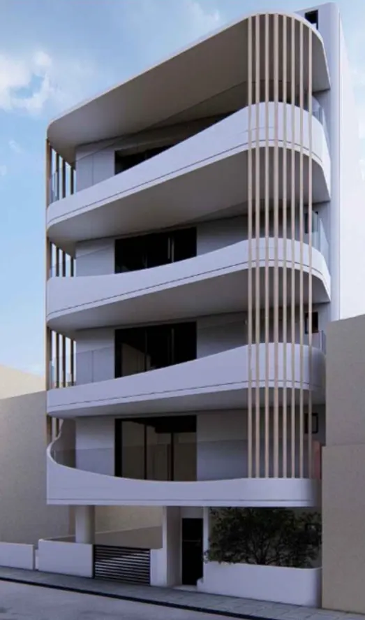 Modern white apartment building with curved balconies and vertical wood slats. Blue sky background.