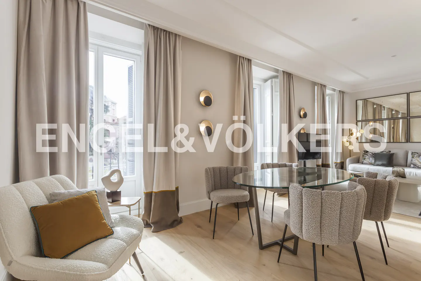 Modern dining area with a glass table, textured chairs, beige curtains, and a cozy armchair with a mustard yellow pillow.