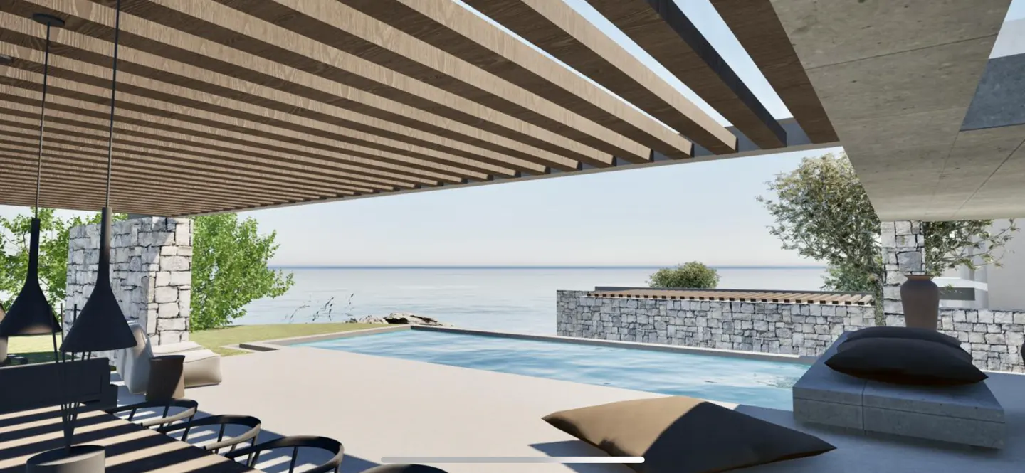 Outdoor patio with a pool overlooking the ocean. The patio has a wooden pergola, stone walls, and modern furniture.