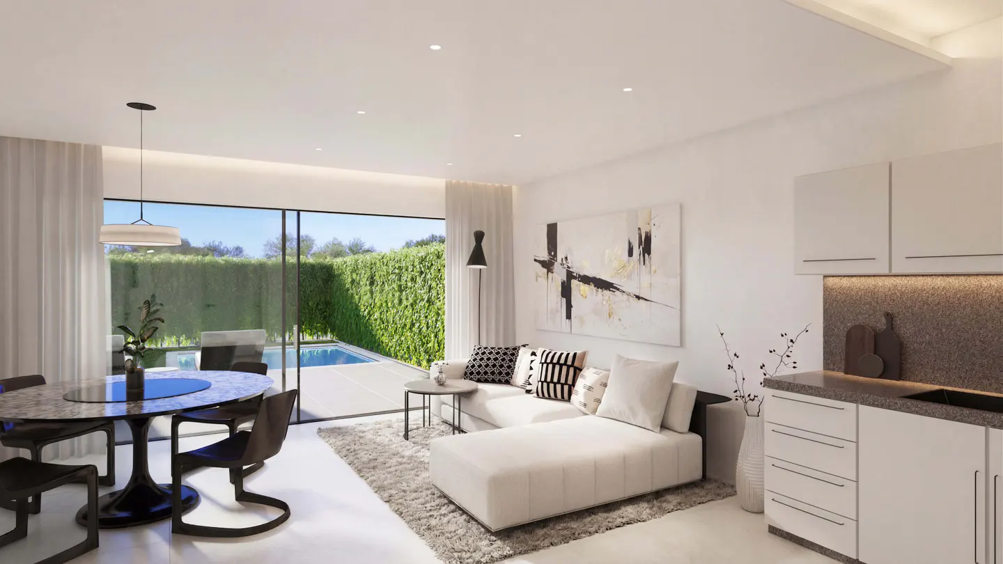 Bright, modern living space with white walls, a white sectional sofa, and a dining table. A pool is visible through a large glass door.