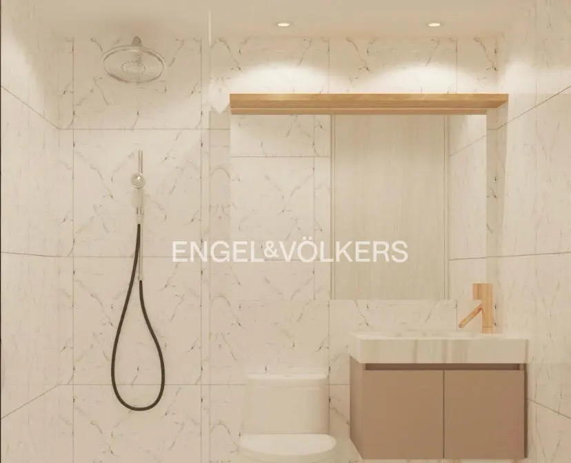 A modern bathroom with marble-patterned walls, a shower, a toilet, and a vanity with a light brown cabinet.