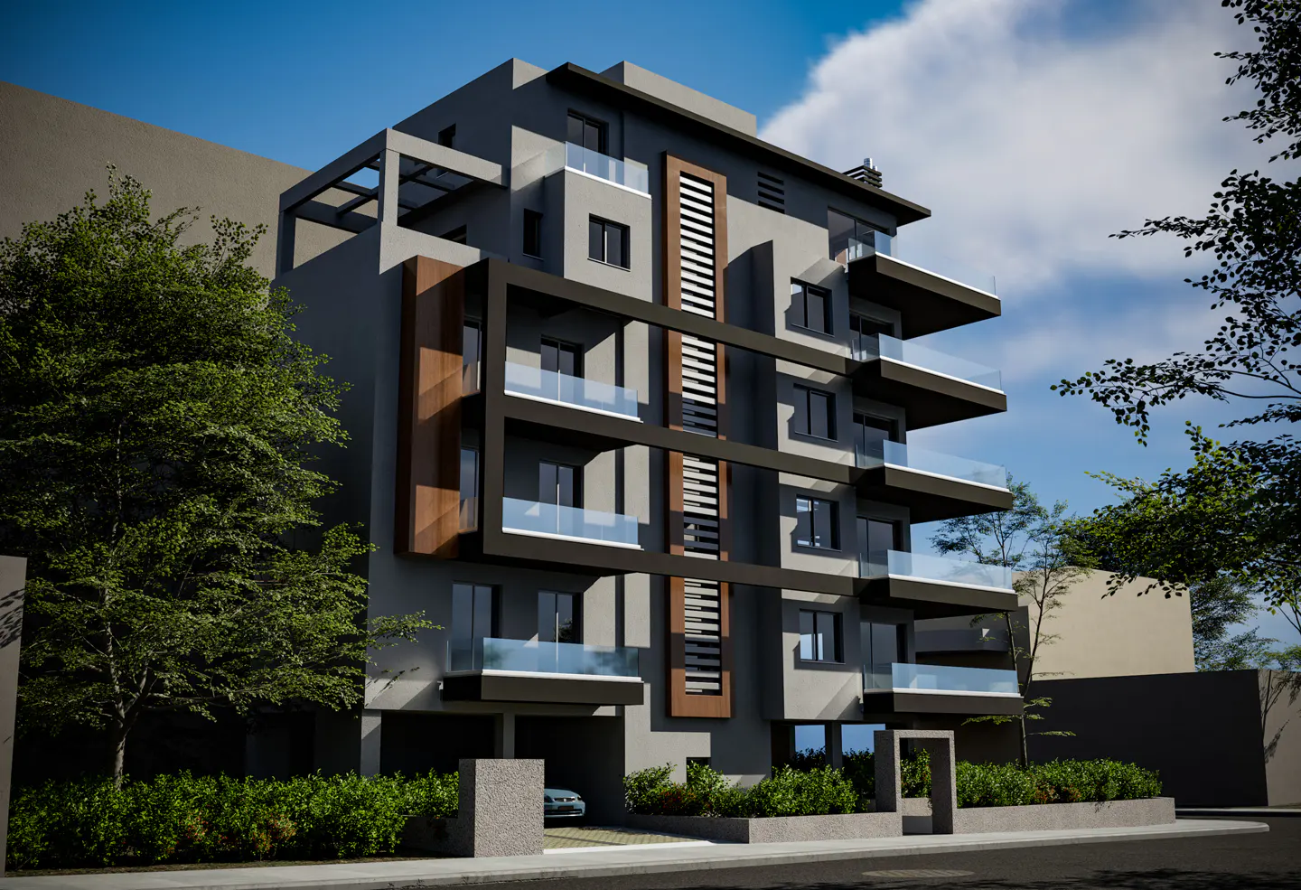 Modern gray apartment building with black accents and glass balconies, surrounded by green trees and bushes.