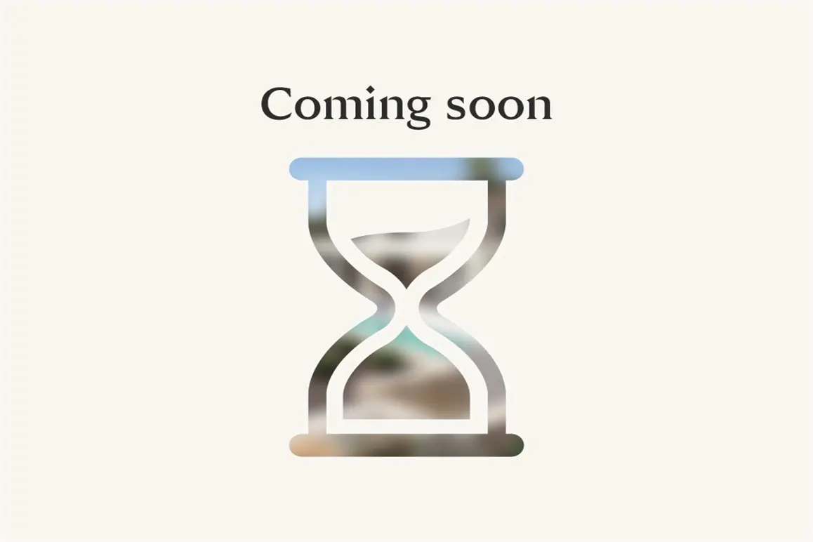 "Coming soon" text above an hourglass icon filled with a blurred outdoor scene, set against a cream background.