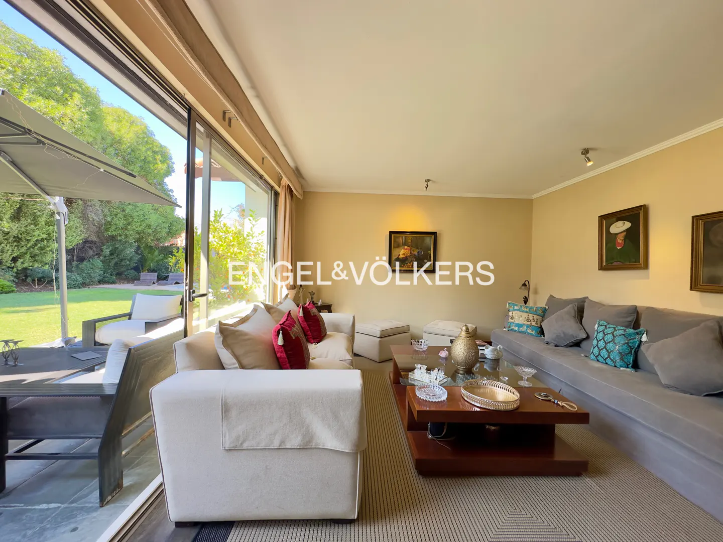 Living room with white and gray sofas, a brown coffee table, and a view of a green lawn through a large sliding glass door.
