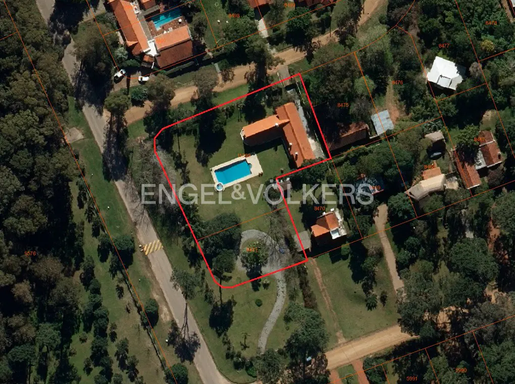 Aerial view of a property with a red outline, featuring a house, pool, and Engel & Volkers logo.