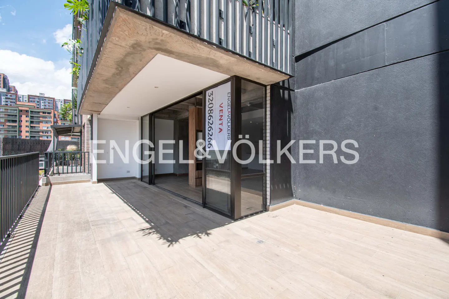 Exterior view of a modern apartment building with a balcony and Engel & Völkers signage.
