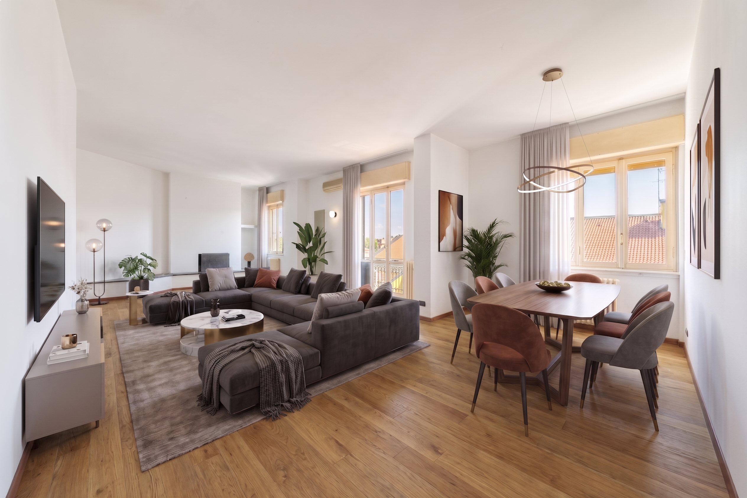 Bright, open-concept living and dining area with wood floors. A gray sectional sofa faces a TV. A wood table with six chairs sits near a window.