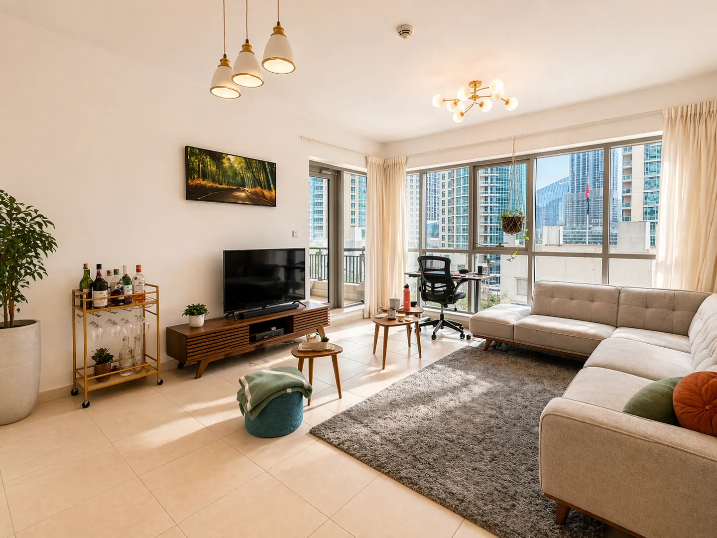 Bright living room with beige tile floor, gray rug, sectional sofa, TV, bar cart, and city view through large windows.