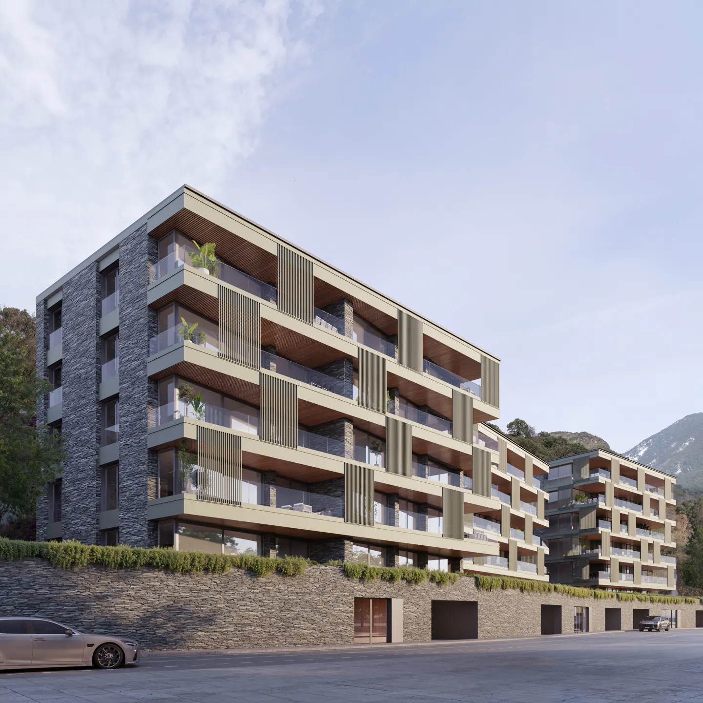 Modern multi-story apartment building with stone facade, glass balconies, and wooden accents against a mountain backdrop.