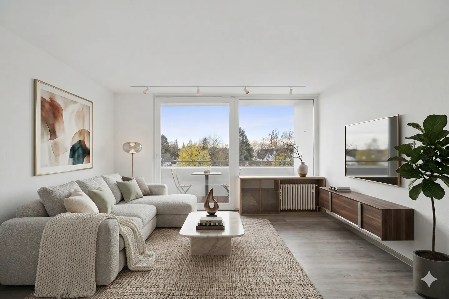 Bright living room with a gray sectional sofa, marble coffee table, and a balcony view of trees. Artwork and a TV decorate the white walls.