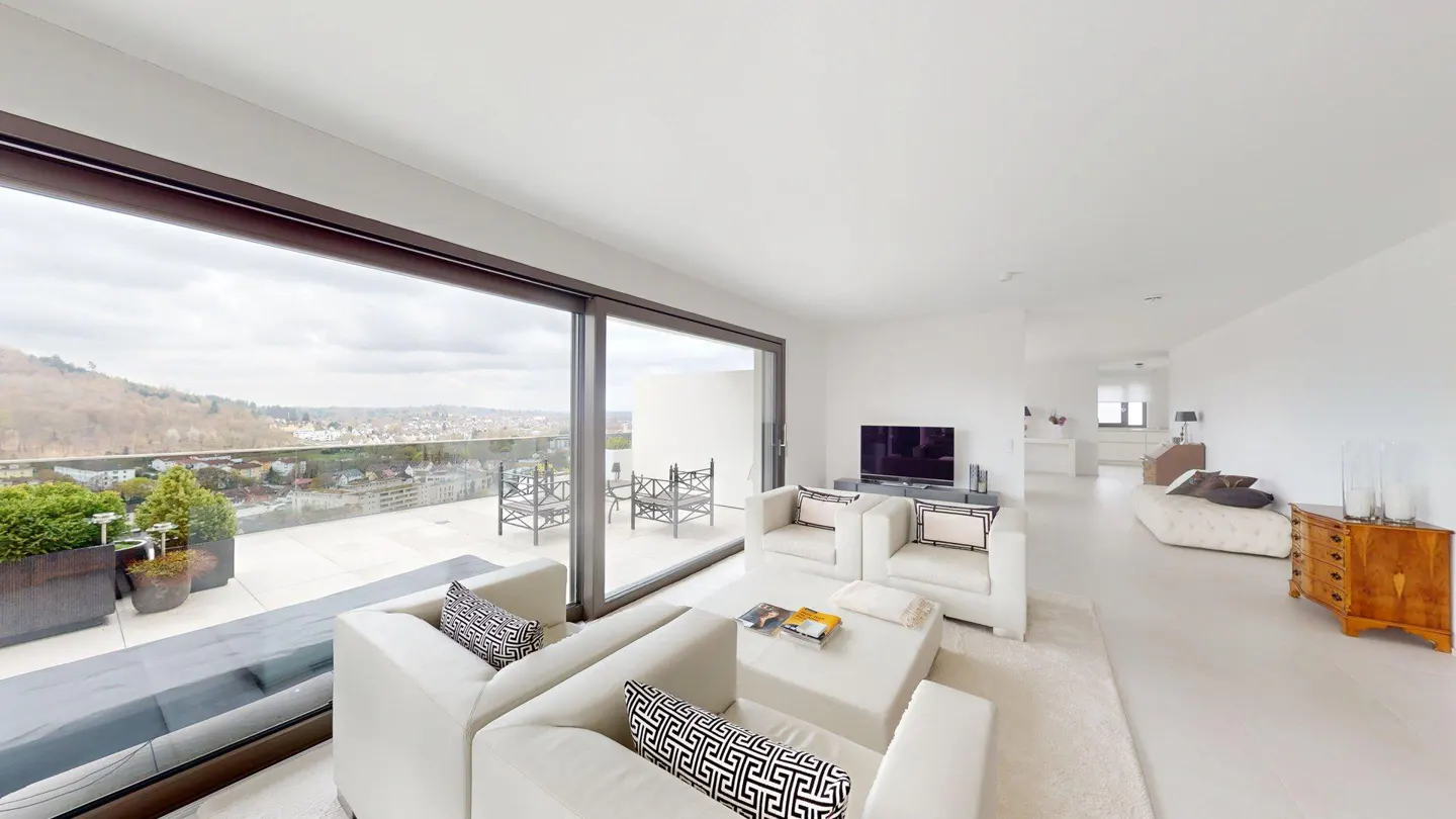 Bright, modern living room with white sofas, TV, and a large window overlooking a terrace with city views.