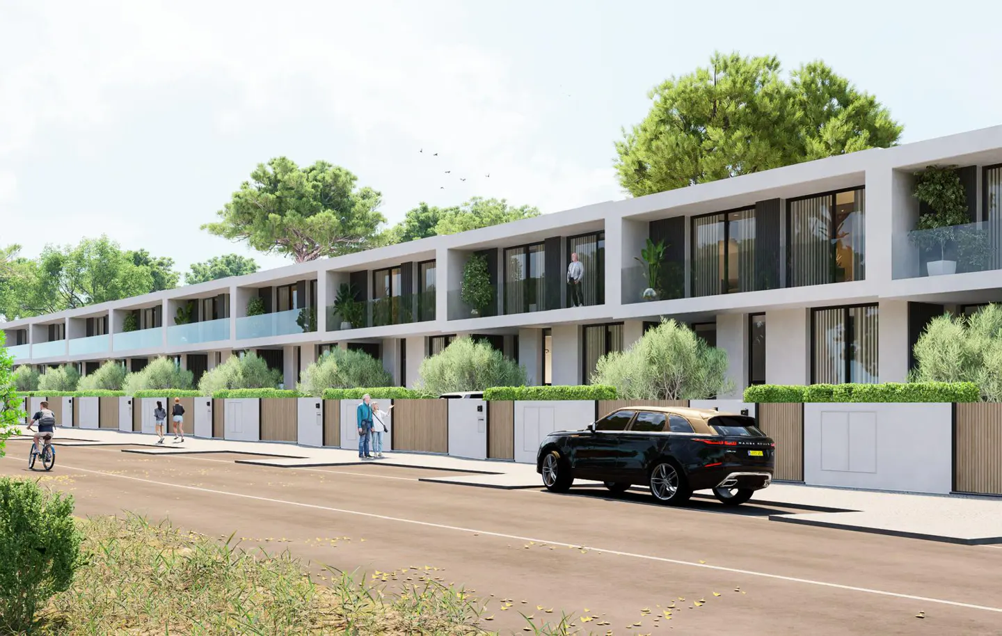 Row of modern townhouses with white facades, glass balconies, and green landscaping. People walk and bike on the sidewalk, and a black SUV is parked nearby.