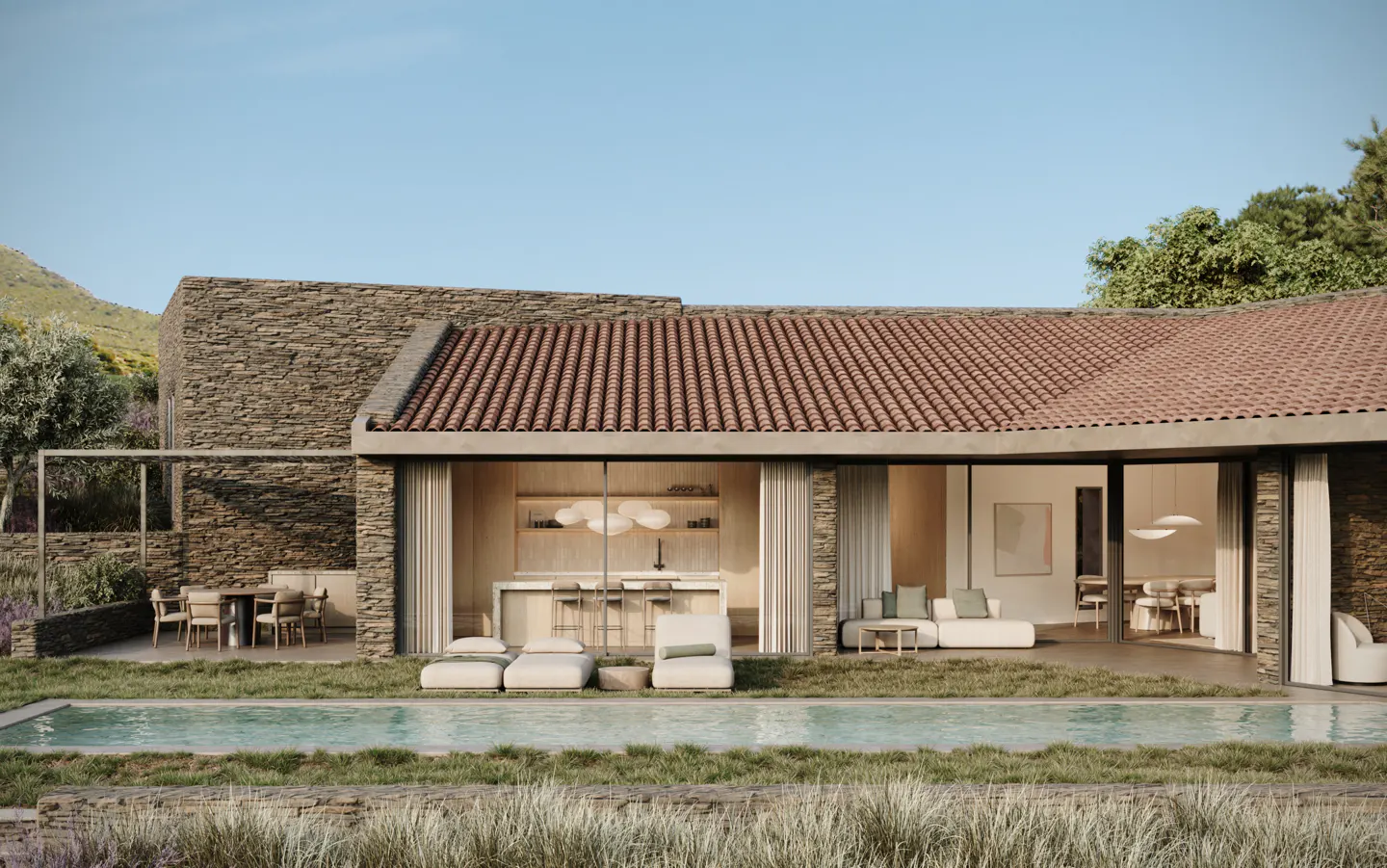 Exterior view of a stone house with a red tile roof, pool, and outdoor seating area on a sunny day.