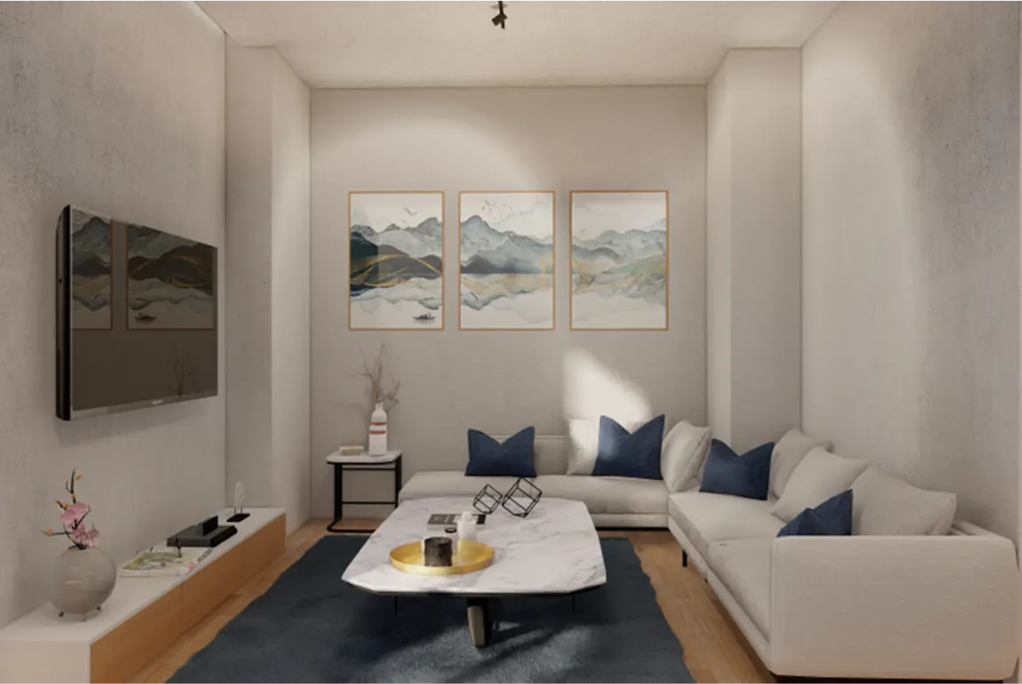 Living room with white walls, blue rug, and white sectional sofa with blue pillows. Three framed landscape paintings hang above the sofa.