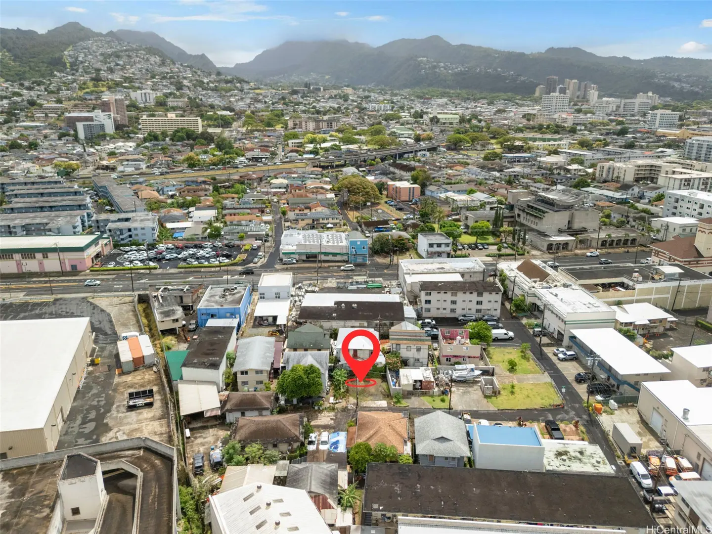 Aerial view of a property with a red pin in a city with mountains in the background.