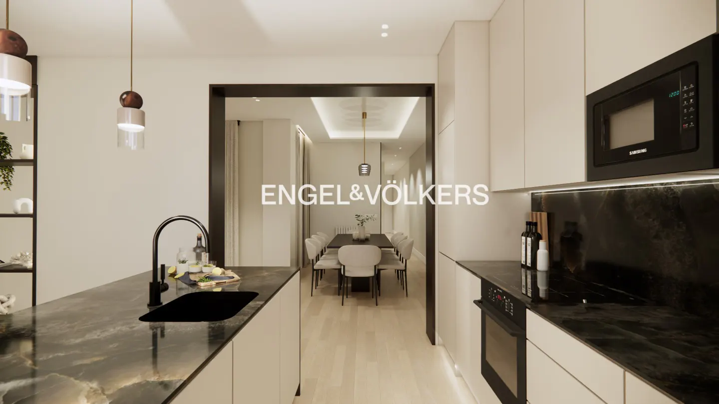 Modern kitchen with black marble countertops, light cabinets, and a view into a dining room with a long table and chairs.