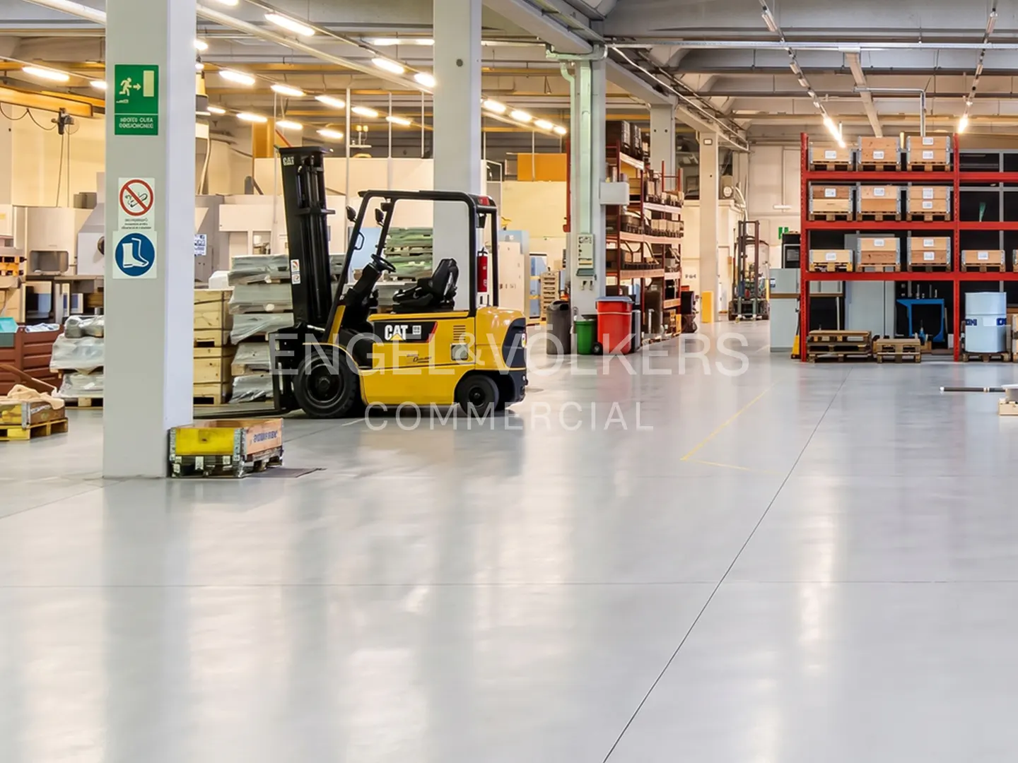 Bright, spacious warehouse interior with a yellow CAT forklift, red shelving, and safety signs on a white pillar.