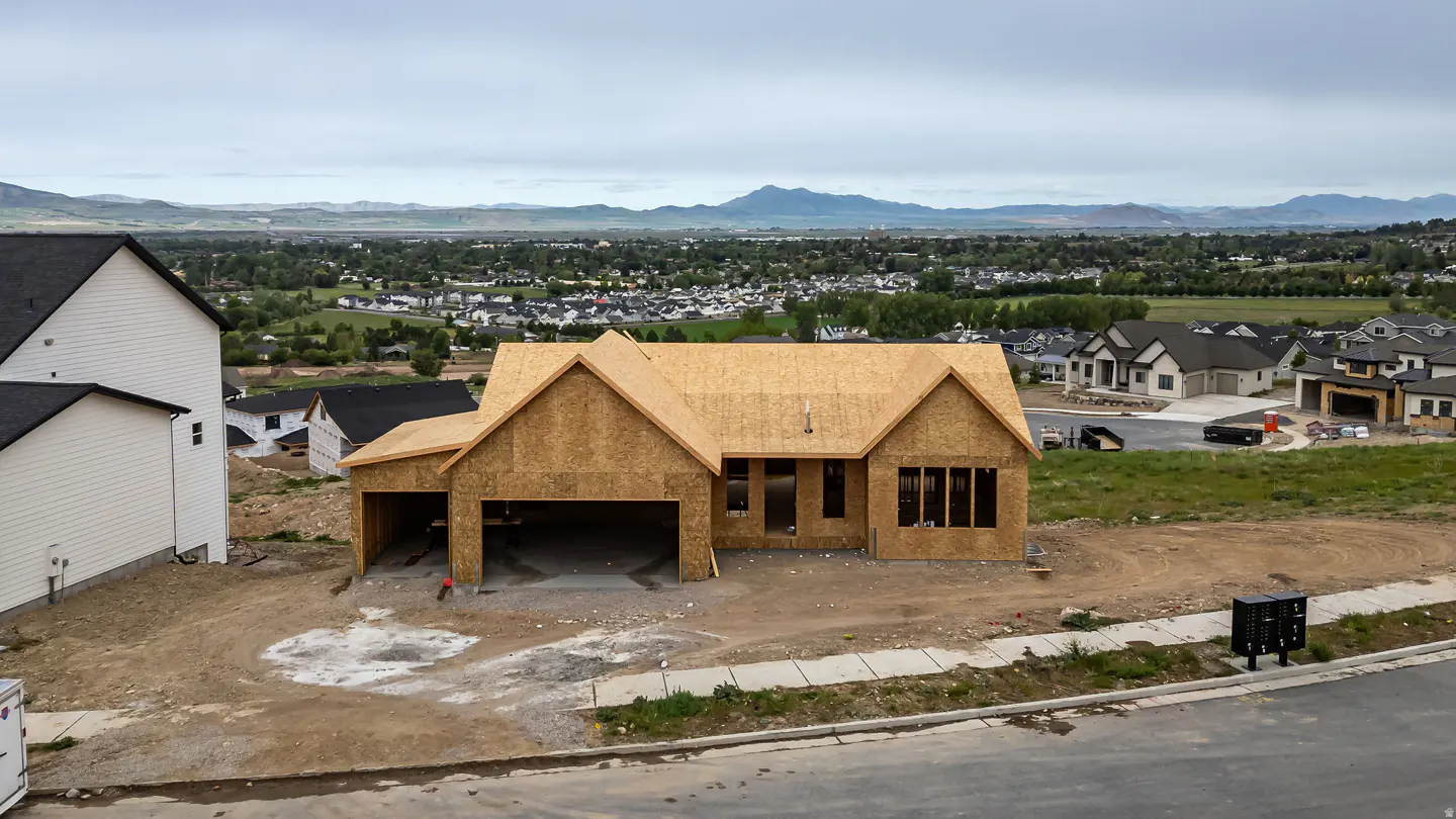 Unfinished wood-framed house with a garage, set in a new development with mountain views.