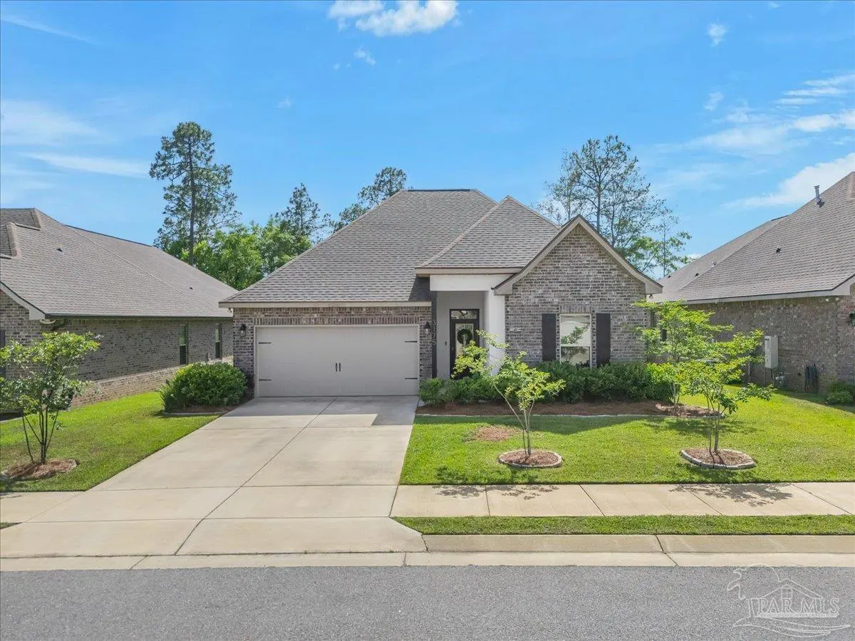 A single-story brick house with a gray roof, white trim, and a two-car garage on a sunny day.