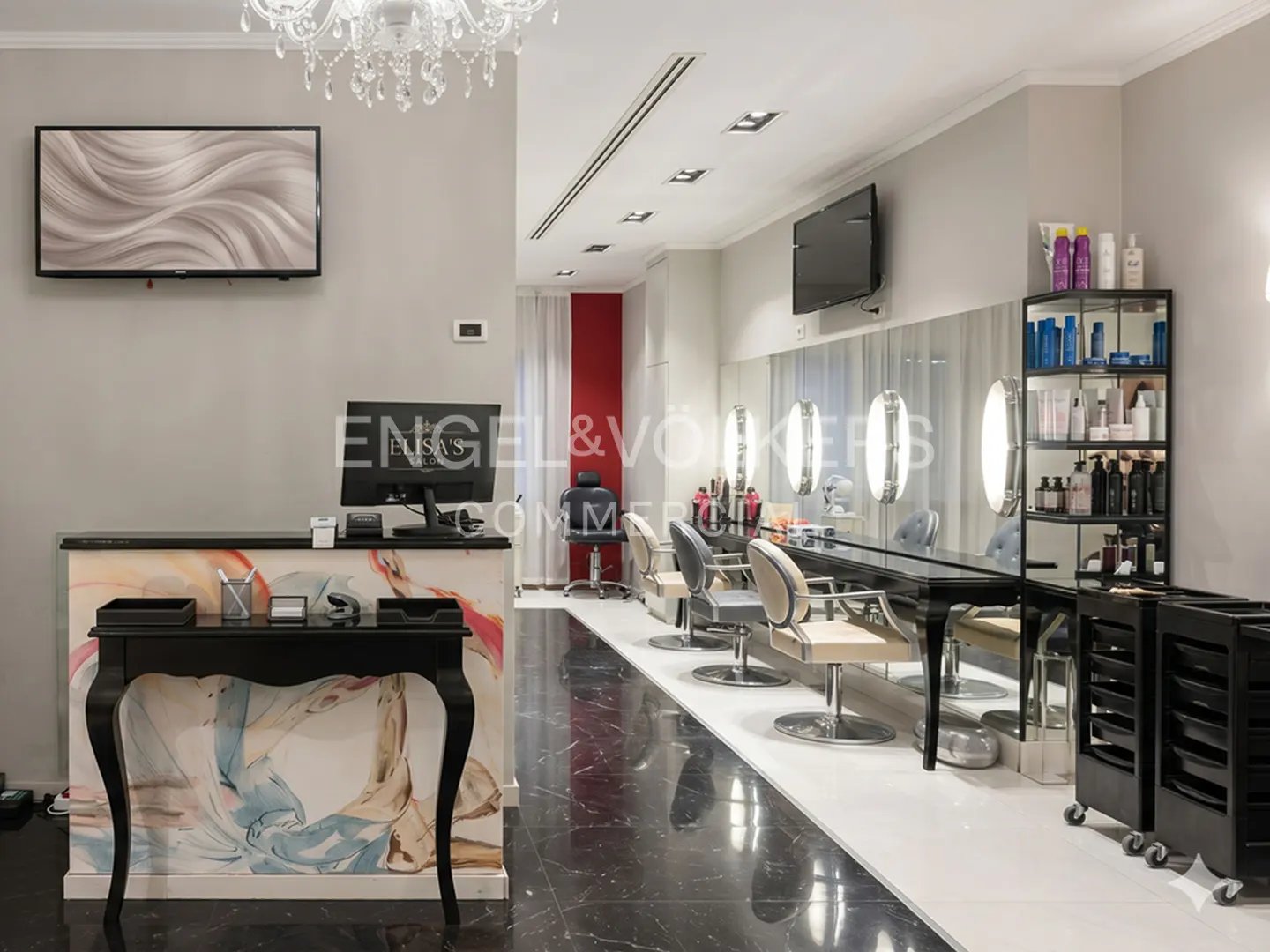 Salon interior with black marble floors, a reception desk, styling stations with chairs, and product shelves.