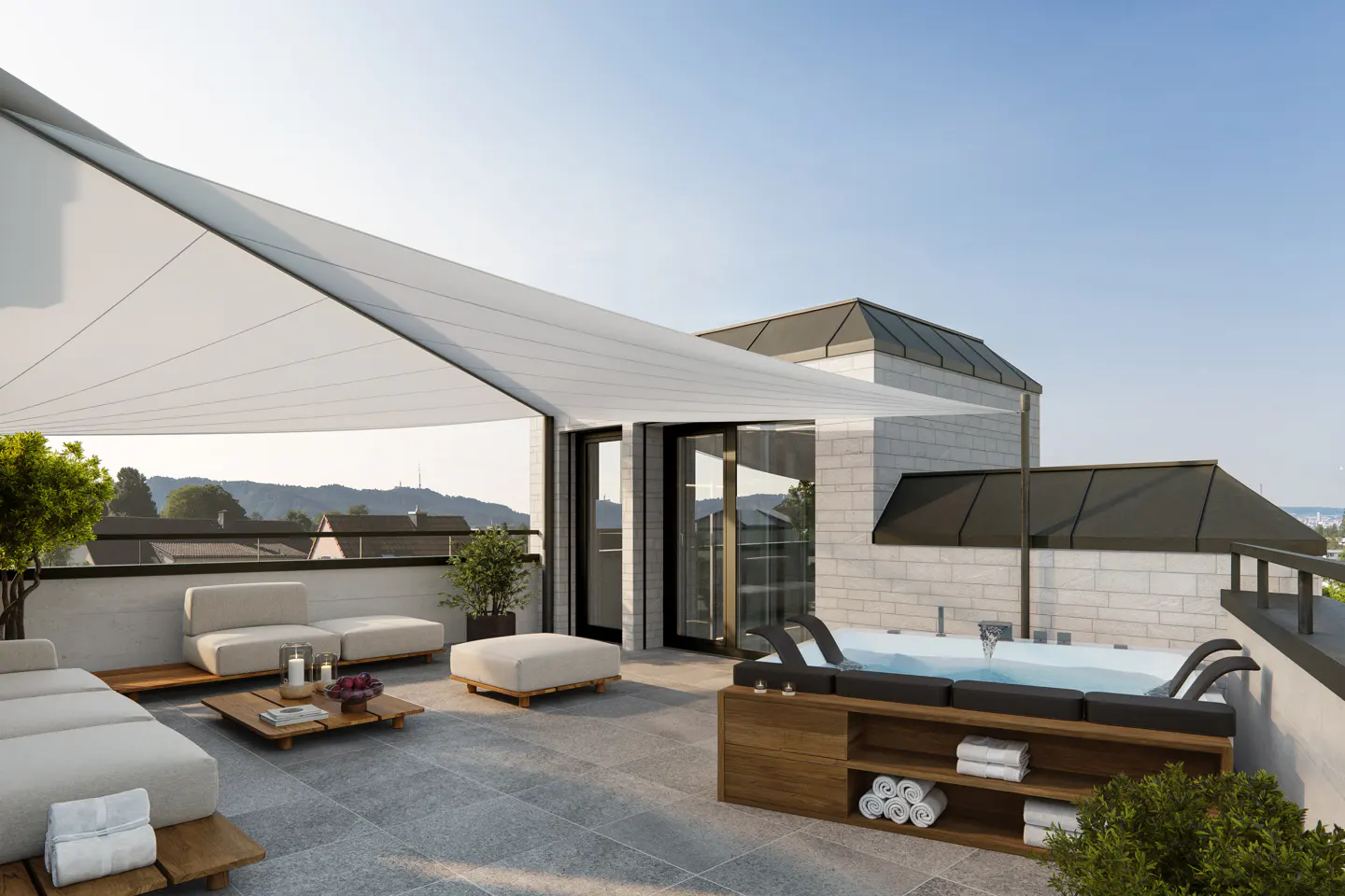 Rooftop patio with a hot tub, lounge chairs, and a white awning. The patio has a view of the city and mountains in the background.