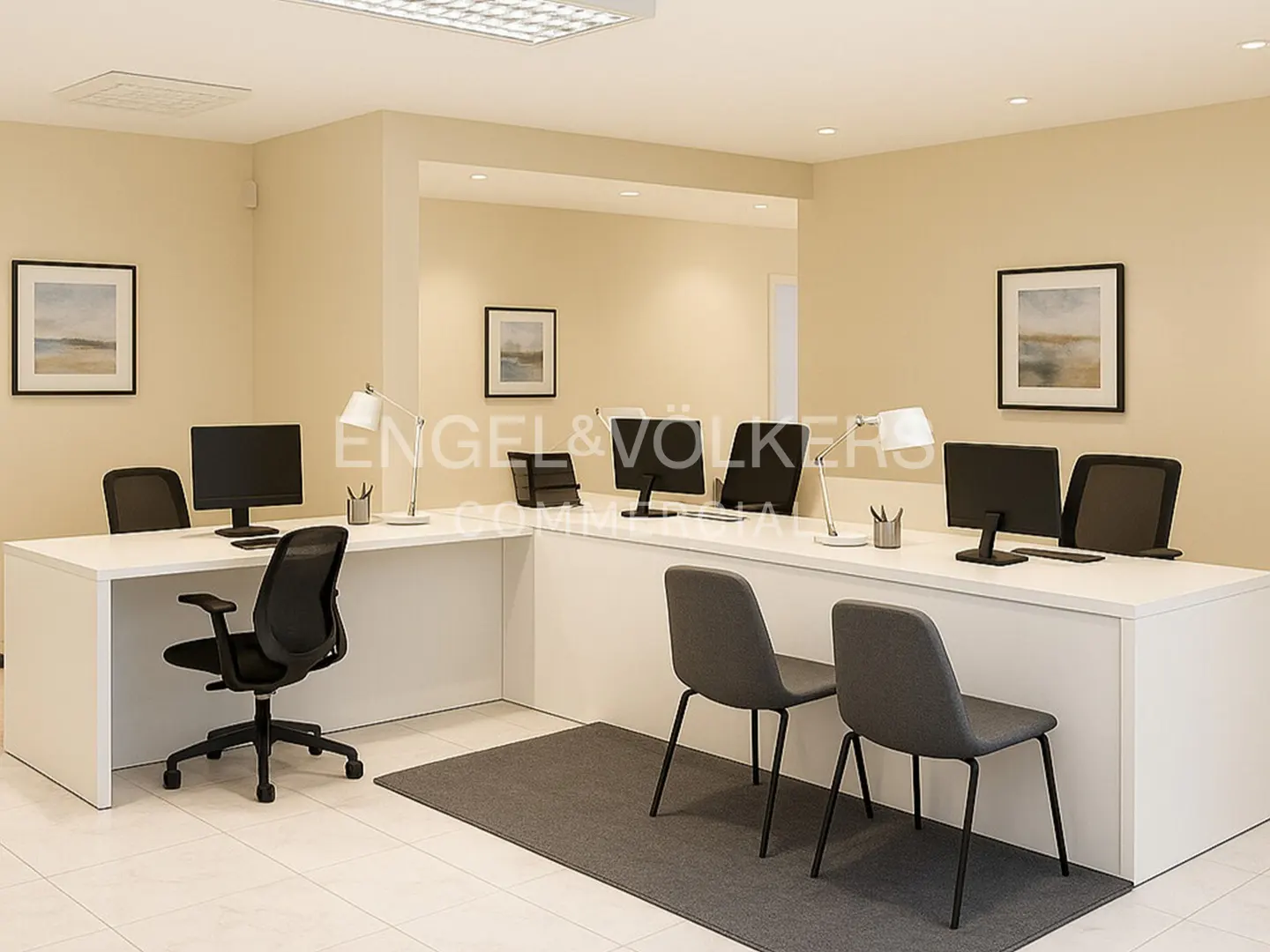 Office space with white desks, black chairs, and computers. Gray rugs on the tile floor. Framed art on the beige walls.