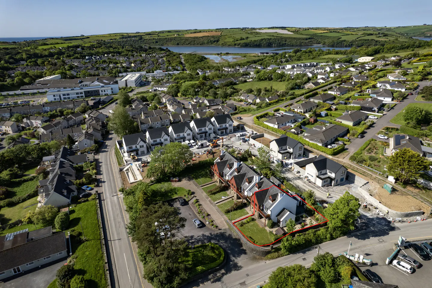 Aerial view of a residential neighborhood with a red outline highlighting a modern house and its garden.