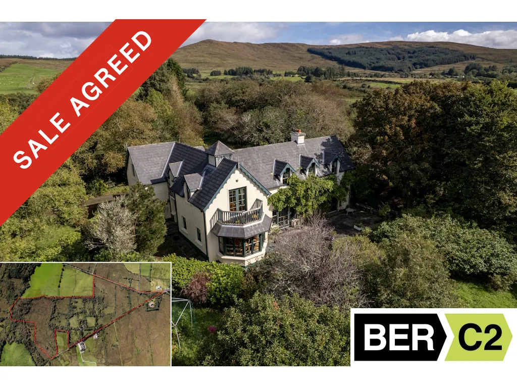 Aerial view of a cream house with a grey roof, surrounded by trees, with a "Sale Agreed" banner and a BER C2 logo.