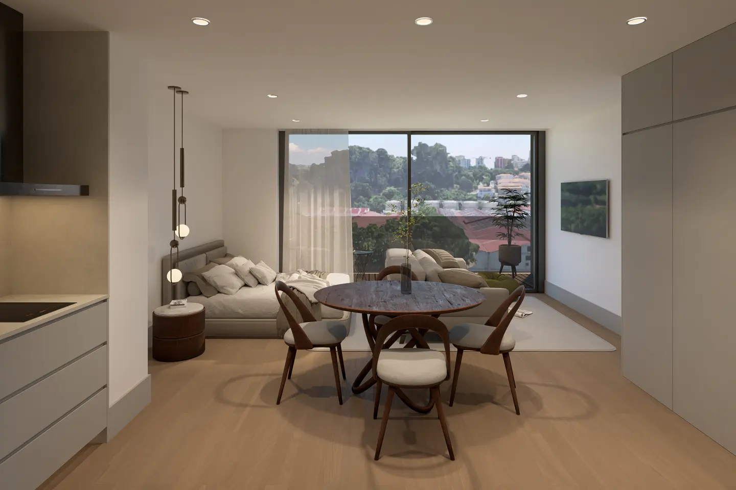 A modern apartment interior with a round wooden table and four chairs. A bed and sofa are visible in the background, with a city view through a large window.