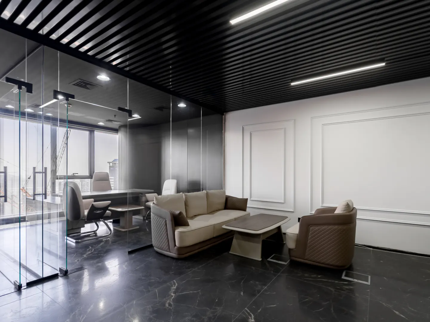 A modern office interior with a glass-walled conference room, a beige sofa, and a black marble floor.