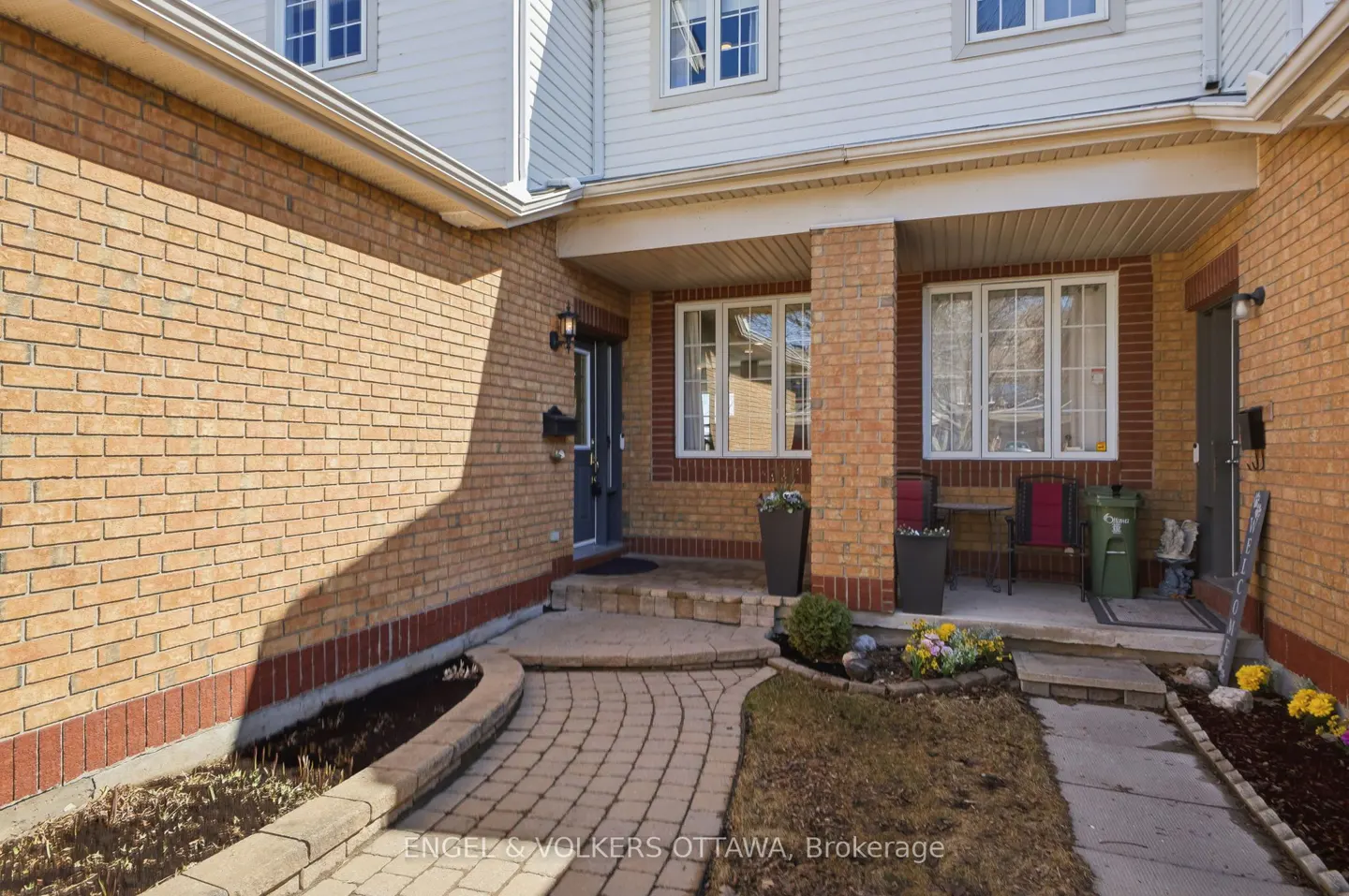Exterior view of a two-story brick house with a stone walkway leading to the front door and porch.