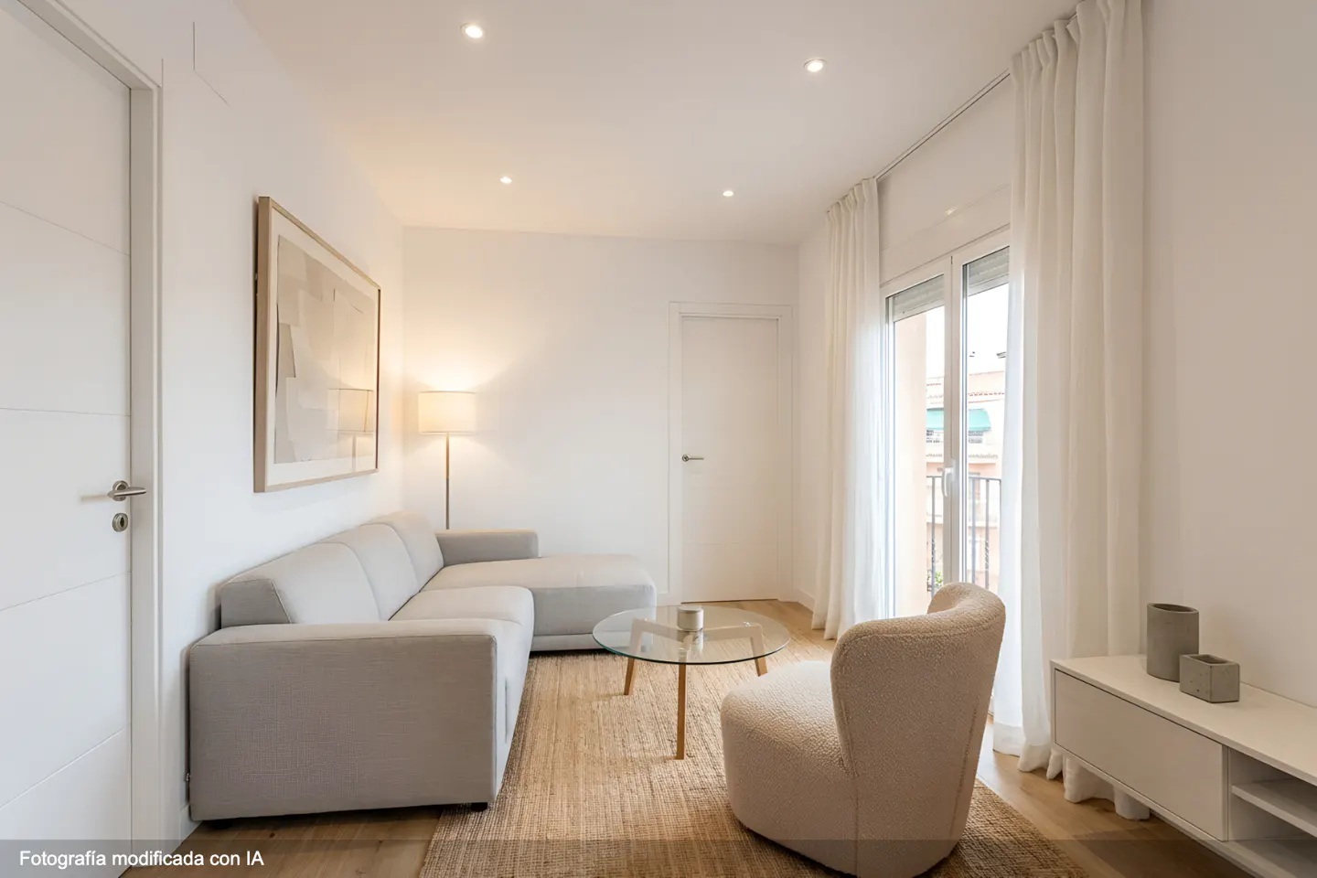 Bright living room with a gray sectional sofa, glass coffee table, and beige armchair on a jute rug. White walls, curtains, and a door complete the modern look.