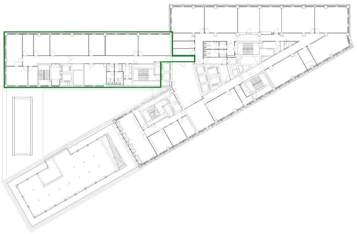 Floor plan of a building with a section highlighted in green, showing offices, stairs, and restrooms.