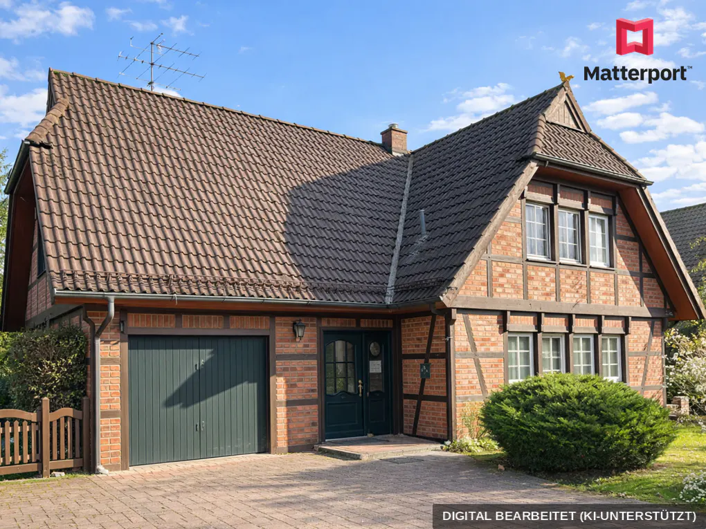 Exterior view of a two-story brick house with a brown tiled roof, green garage door and front door, and a paved driveway.