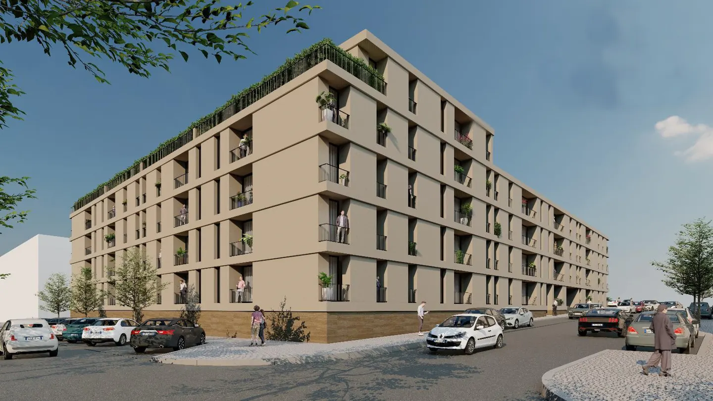 A tan apartment building with black balconies and potted plants, cars parked in front.