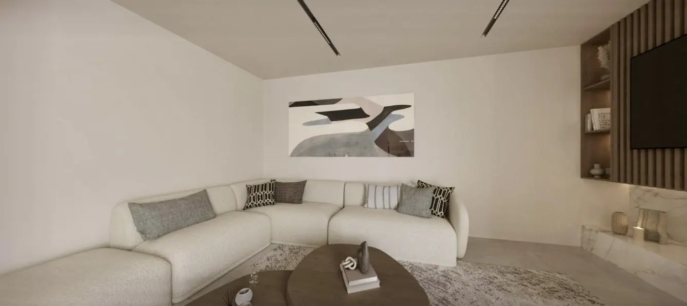 Living room with a white sectional sofa, abstract art, and a brown coffee table on a patterned rug. A TV and shelves are on the right.