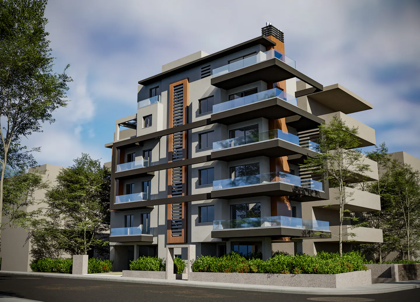 Modern gray apartment building with black trim and glass balconies, surrounded by green trees and a blue sky.