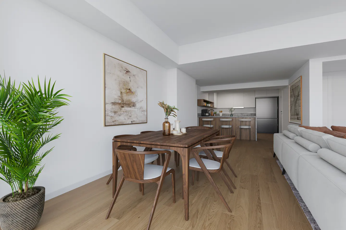 Open-concept living space with a wood dining table, white chairs, and a modern kitchen in the background. A large plant sits near an abstract painting.